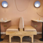 Beige leather bench seat between two tables at Bocca Bocca 