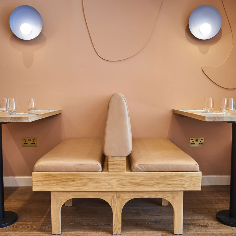 Beige leather bench seat between two tables at Bocca Bocca 