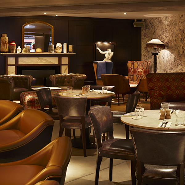 Lounge area with tan leather armchairs at 100 Wardour Street