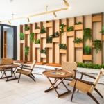 Seating area with woven chairs beside a planted wall at Chelsea Crescent 